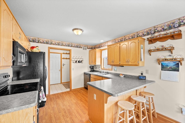 2101 Blake Ave, Lester Prairie, MN 55354 - kitchen with black microwave, a peninsula, range with electric stovetop, a breakfast bar area, and stainless steel dishwasher