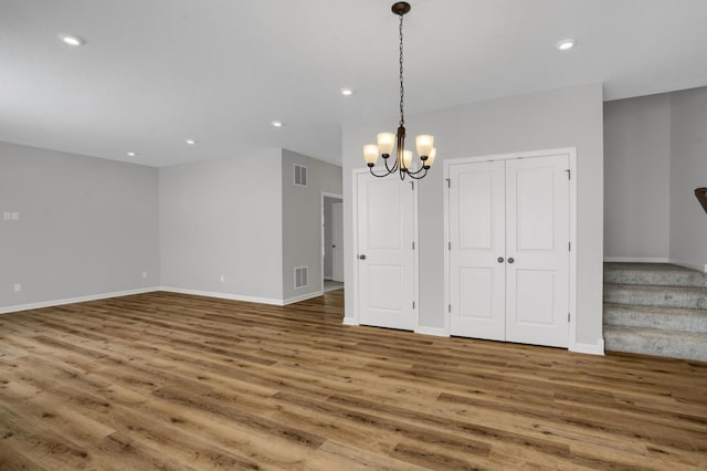 10664 29th St NE, Saint Michael, MN 55376 - empty room with wood finished floors, a chandelier, recessed lighting, baseboards, and stairs