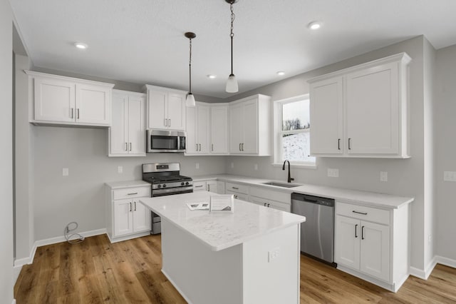 10664 29th St NE, Saint Michael, MN 55376 - kitchen featuring appliances with stainless steel finishes, a sink, white cabinetry, a center island, and recessed lighting