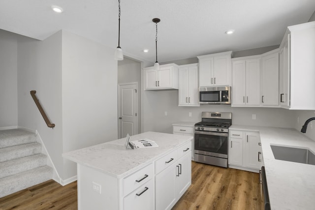 10664 29th St NE, Saint Michael, MN 55376 - kitchen featuring stainless steel appliances, a sink, light wood-style flooring, recessed lighting, and a kitchen island
