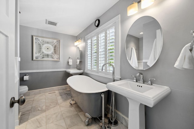 17209 Grays Bay Blvd, Minnetonka, MN 55391 - full bathroom with a freestanding tub, marble finish floors, a sink, toilet, and baseboards