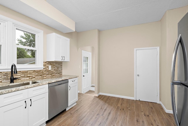 248 Ivy Ave W, Saint Paul, MN 55117 - kitchen with stainless steel appliances, a sink, tasteful backsplash, light wood-type flooring, and baseboards