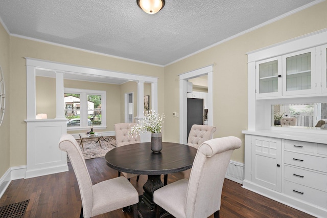 248 Ivy Ave W, Saint Paul, MN 55117 - dining area with dark wood finished floors, decorative columns, a textured ceiling, and crown molding