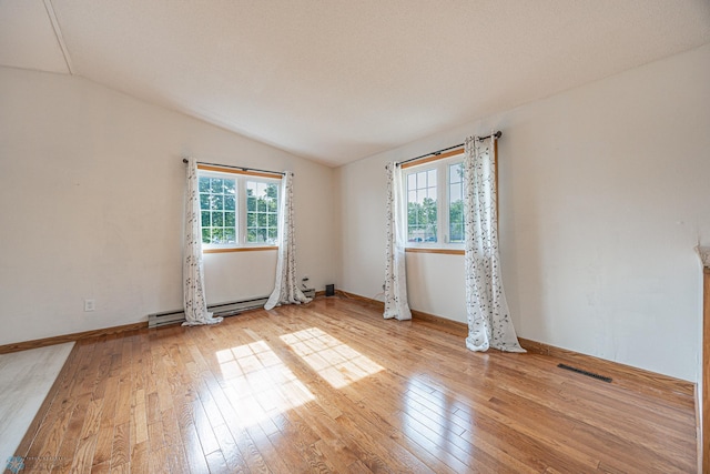 838 8th Ave E, West Fargo, ND 58078 - empty room with vaulted ceiling, light wood-style floors, a baseboard heating unit, and baseboards