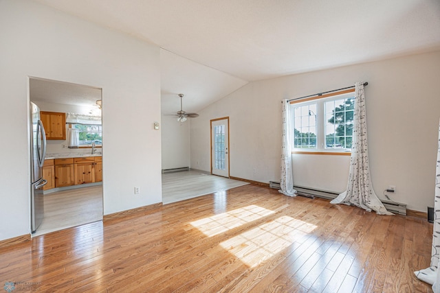 838 8th Ave E, West Fargo, ND 58078 - unfurnished living room with light wood-style floors, a sink, lofted ceiling, ceiling fan, and a baseboard radiator