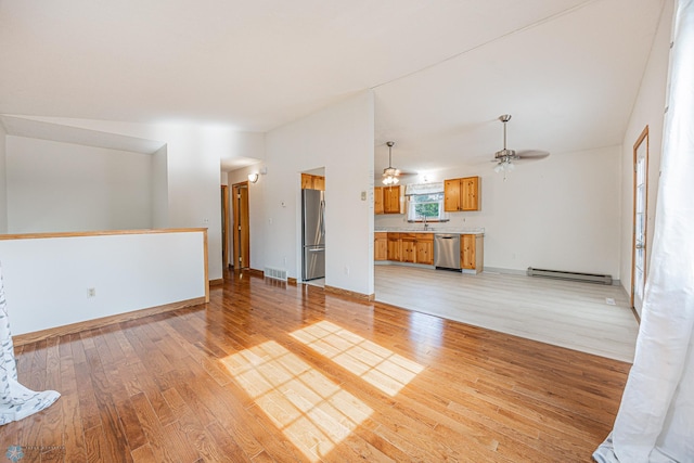 838 8th Ave E, West Fargo, ND 58078 - unfurnished living room featuring a baseboard heating unit, light wood finished floors, ceiling fan, a sink, and baseboards