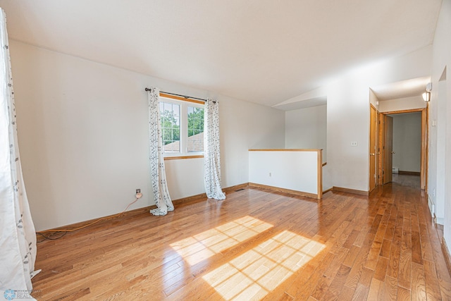 838 8th Ave E, West Fargo, ND 58078 - unfurnished room featuring light wood-style floors, vaulted ceiling, and baseboards