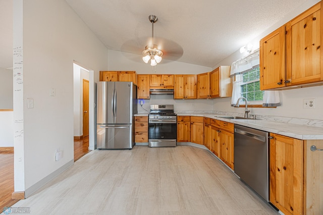 838 8th Ave E, West Fargo, ND 58078 - kitchen with stainless steel appliances, vaulted ceiling, light wood finished floors, light countertops, and a sink