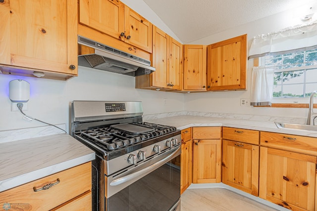 838 8th Ave E, West Fargo, ND 58078 - kitchen featuring gas range, under cabinet range hood, a sink, light countertops, and vaulted ceiling