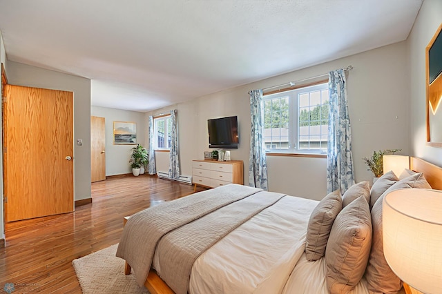 838 8th Ave E, West Fargo, ND 58078 - bedroom featuring multiple windows, wood-type flooring, and baseboards