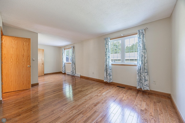 838 8th Ave E, West Fargo, ND 58078 - spare room with healthy amount of natural light, hardwood / wood-style floors, baseboards, and a textured ceiling