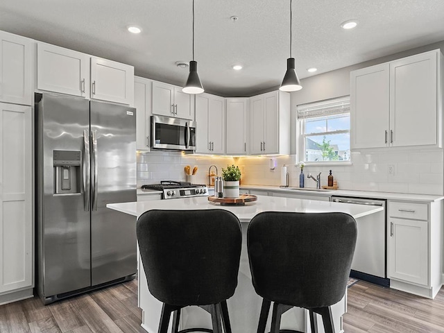 14540 112th Ave N, Dayton, MN 55369 - kitchen with appliances with stainless steel finishes, a sink, light wood-style floors, light countertops, and a center island