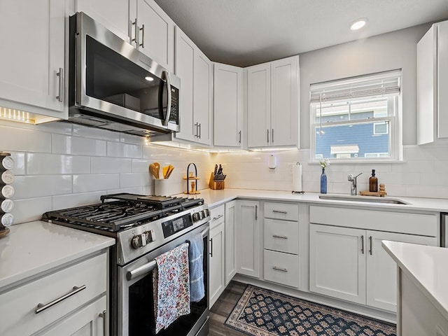 14540 112th Ave N, Dayton, MN 55369 - kitchen featuring stainless steel appliances, a sink, light countertops, white cabinets, and decorative backsplash