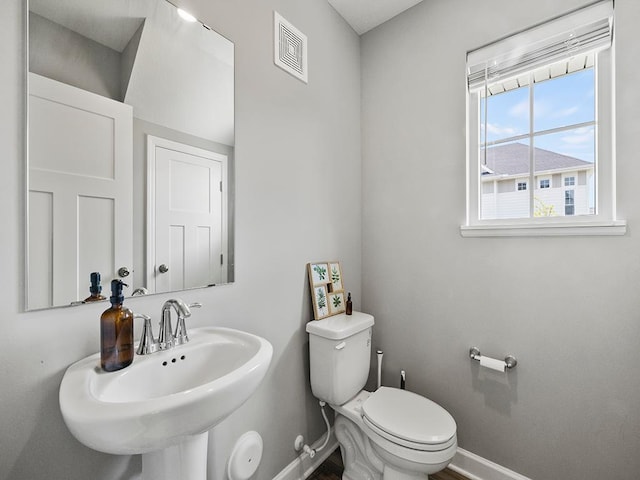 14540 112th Ave N, Dayton, MN 55369 - half bathroom featuring baseboards, toilet, and a sink