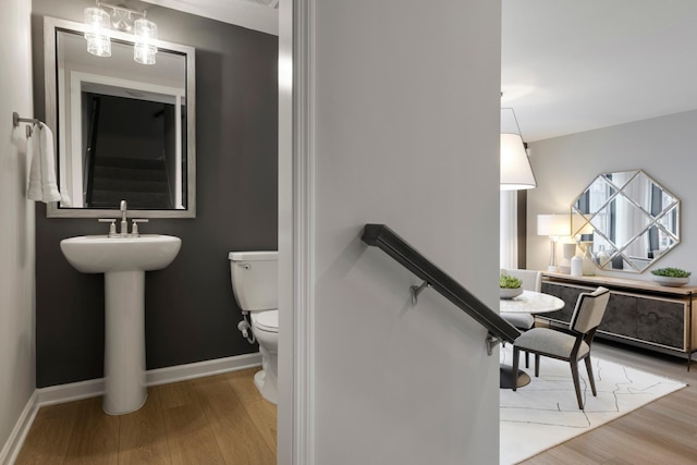 906 Woodlawn Ave Unit D, Saint Paul, MN 55116 - bathroom featuring toilet, wood finished floors, baseboards, and a sink