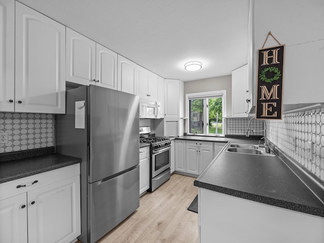 10720 Rockford Rd Unit 113, Plymouth, MN 55442 - kitchen with stainless steel appliances, a sink, white cabinets, light wood-type flooring, and backsplash