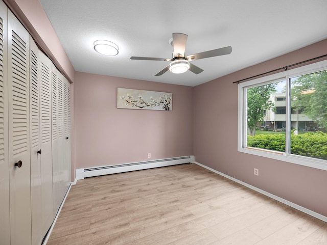 10720 Rockford Rd Unit 113, Plymouth, MN 55442 - unfurnished bedroom featuring light wood-style floors, a closet, baseboards, a baseboard heating unit, and ceiling fan
