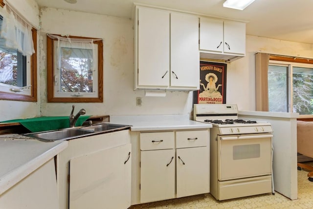 8309 39th St N, Lake Elmo, MN 55042 - kitchen with white range with gas cooktop, light countertops, a sink, white cabinetry, and light flooring