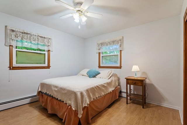 8309 39th St N, Lake Elmo, MN 55042 - bedroom featuring light wood finished floors, a baseboard heating unit, and a ceiling fan