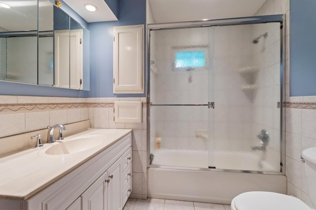 8309 39th St N, Lake Elmo, MN 55042 - bathroom featuring tile walls, toilet, vanity, enclosed tub / shower combo, and tile patterned floors