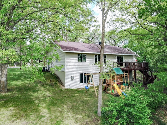 1941 230th St, Saint Croix Falls, WI 54024 - back of property featuring a wooden deck, stairs, a lawn, and a playground