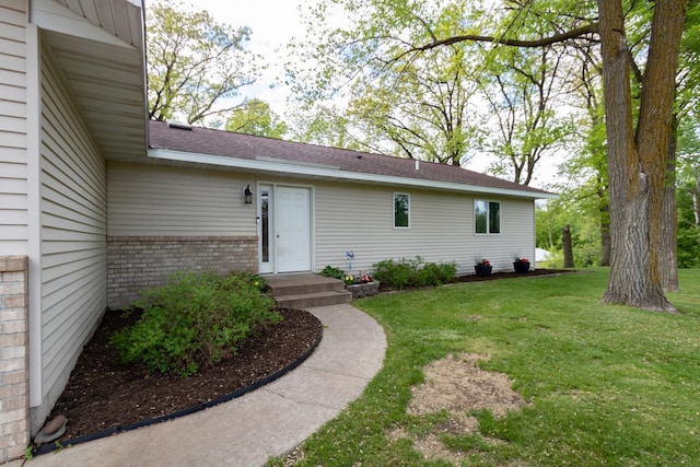 1941 230th St, Saint Croix Falls, WI 54024 - property entrance with a lawn, brick siding, and roof with shingles