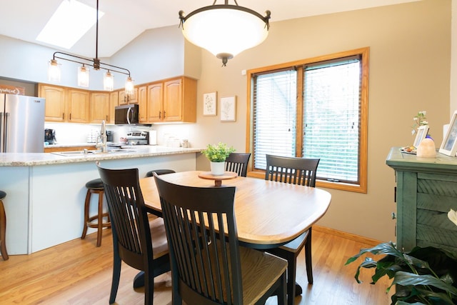 1941 230th St, Saint Croix Falls, WI 54024 - dining space with light wood-type flooring, a skylight, and high vaulted ceiling