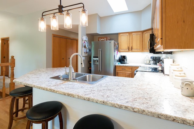 1941 230th St, Saint Croix Falls, WI 54024 - kitchen with stainless steel appliances, a sink, a skylight, a kitchen breakfast bar, and a peninsula
