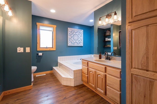 1941 230th St, Saint Croix Falls, WI 54024 - bathroom featuring vanity, toilet, a bath, baseboards, and wood finished floors