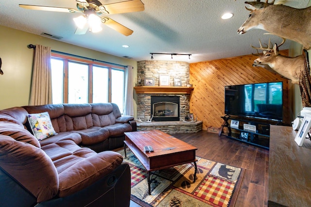 1941 230th St, Saint Croix Falls, WI 54024 - living area with a ceiling fan, wood finished floors, track lighting, a stone fireplace, and a textured ceiling
