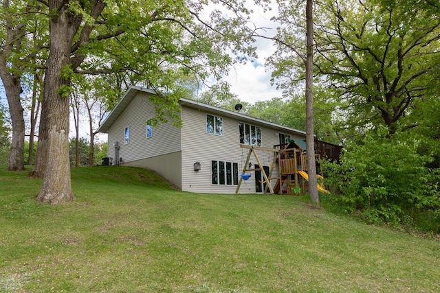 1941 230th St, Saint Croix Falls, WI 54024 - back of property featuring a lawn, stairway, a deck, and central AC