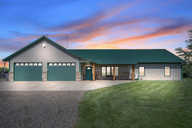 10080 550th St, Rock Creek, MN 55069 - view of front facade with driveway, a garage, a lawn, stone siding, and metal roof