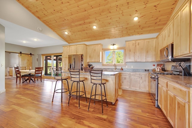10080 550th St, Rock Creek, MN 55069 - kitchen featuring appliances with stainless steel finishes, light brown cabinets, a kitchen breakfast bar, a sink, and a kitchen island