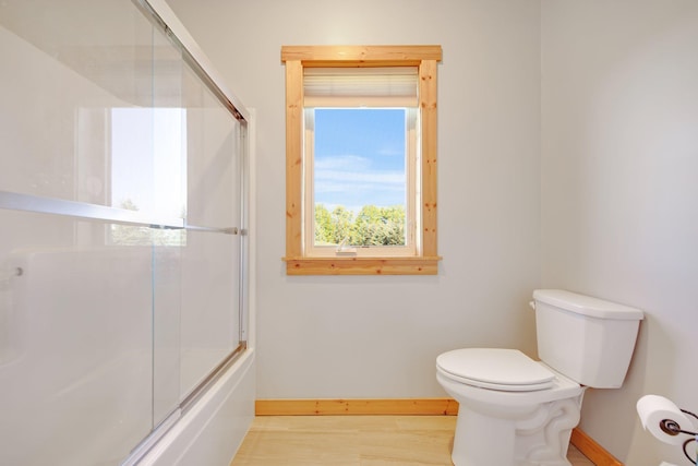 10080 550th St, Rock Creek, MN 55069 - bathroom with baseboards, toilet, wood finished floors, and combined bath / shower with glass door
