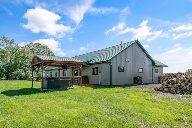 10080 550th St, Rock Creek, MN 55069 - back of house featuring a hot tub, a gazebo, metal roof, a standing seam roof, and a lawn