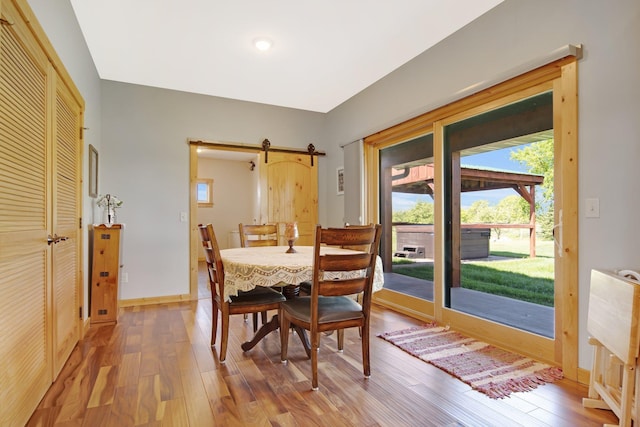 10080 550th St, Rock Creek, MN 55069 - dining room featuring wood finished floors, a barn door, and baseboards