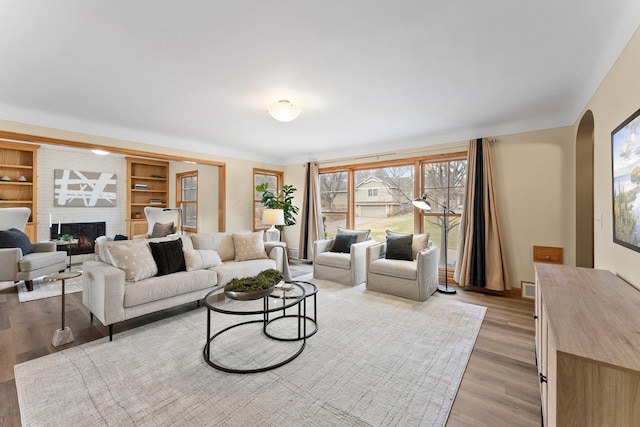 2701 Princeton Ave, Saint Louis Park, MN 55416 - living room with arched walkways, light wood-type flooring, and a brick fireplace