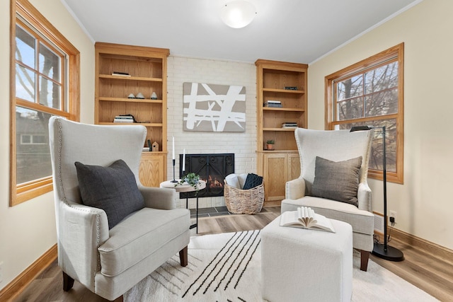 2701 Princeton Ave, Saint Louis Park, MN 55416 - sitting room featuring baseboards, wood finished floors, ornamental molding, and a brick fireplace