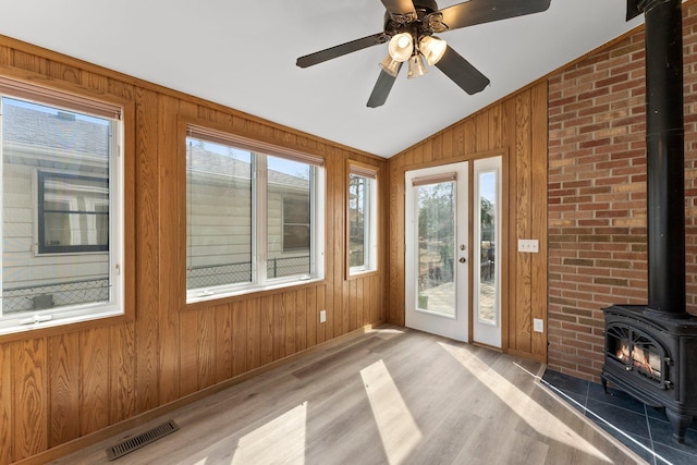 2701 Princeton Ave, Saint Louis Park, MN 55416 - unfurnished sunroom featuring a wood stove, lofted ceiling, wood finished floors, plenty of natural light, and wooden walls