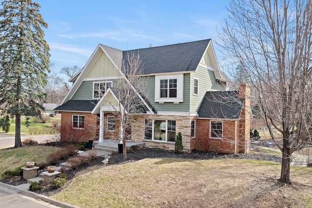 2701 Princeton Ave, Saint Louis Park, MN 55416 - view of front of home with roof with shingles, stone siding, a front lawn, a chimney, and board and batten siding
