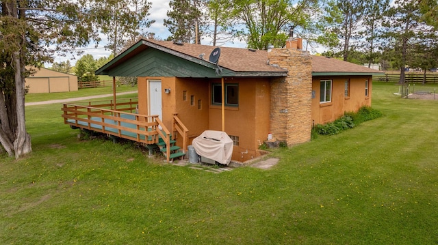 36037 678th St, Hill Lake Twp, MN 55748 - back of house with stucco siding, a chimney, and roof with shingles