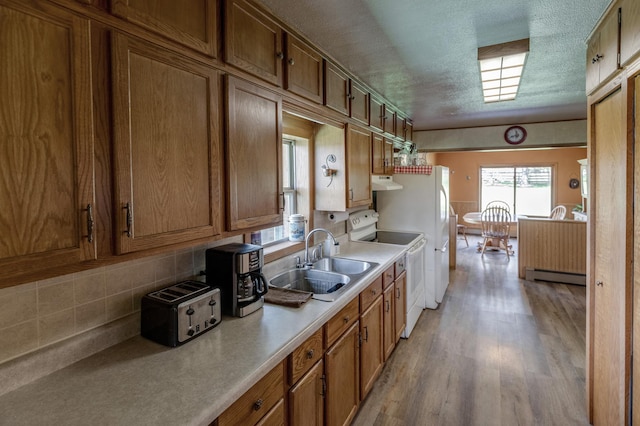 36037 678th St, Hill Lake Twp, MN 55748 - kitchen featuring white electric range, a sink, brown cabinetry, a baseboard radiator, and tasteful backsplash