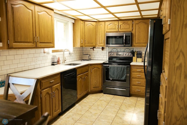 806 E St, Bottineau, ND 58318 - kitchen featuring black appliances, a sink, brown cabinets, and decorative backsplash