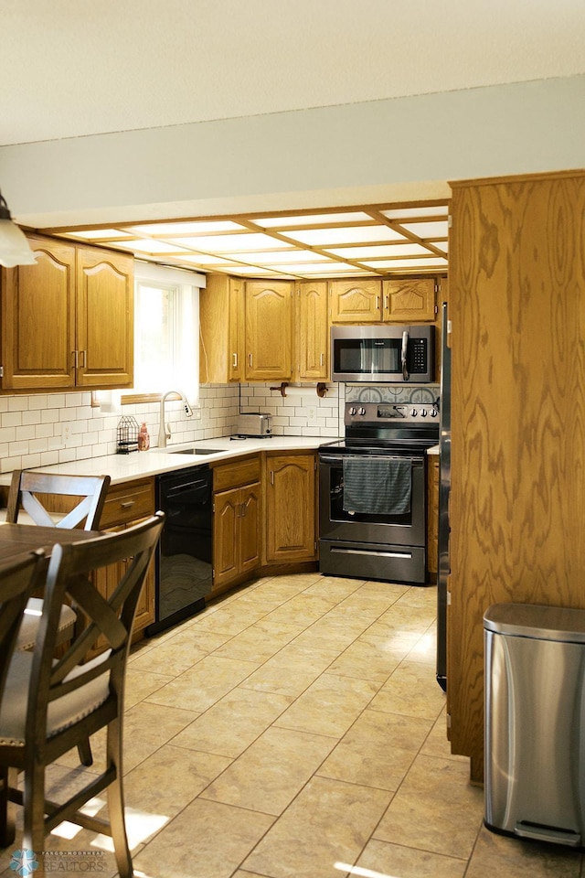 806 E St, Bottineau, ND 58318 - kitchen featuring electric stove, stainless steel microwave, black dishwasher, a sink, and tasteful backsplash