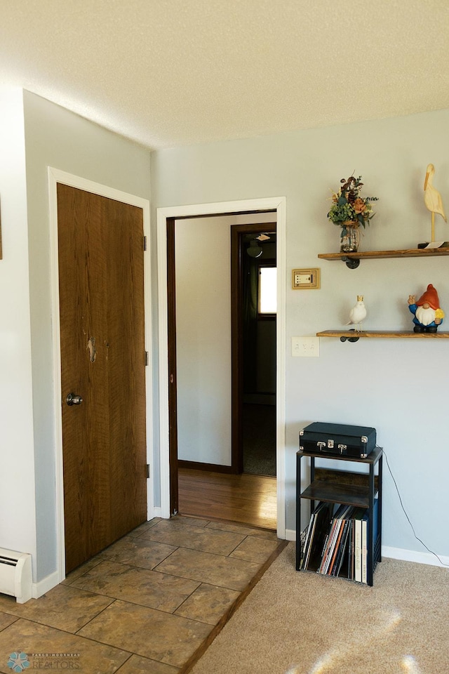 806 E St, Bottineau, ND 58318 - hallway with a baseboard heating unit and baseboards