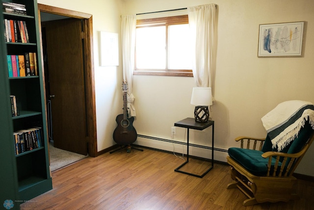 806 E St, Bottineau, ND 58318 - living area with a baseboard heating unit and wood finished floors