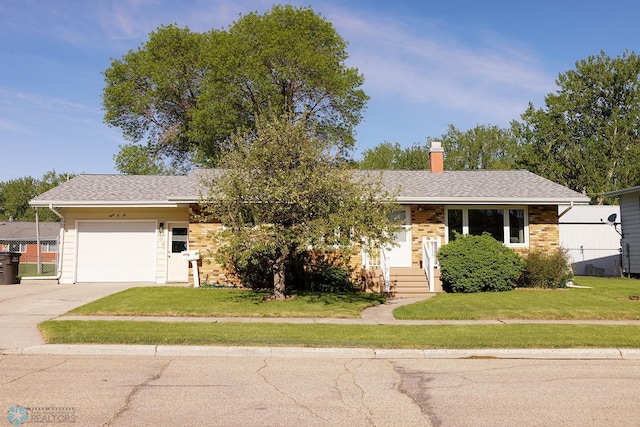 806 E St, Bottineau, ND 58318 - view of front facade featuring an attached garage, a front lawn, concrete driveway, and a chimney