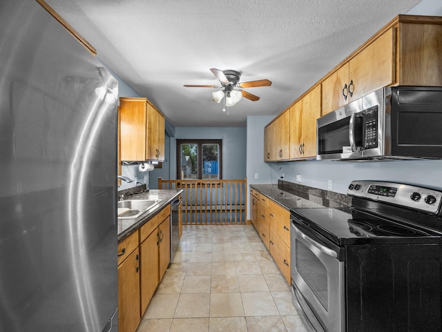 5252 5th St NE, Columbia Heights, MN 55421 - kitchen with stainless steel appliances, dark countertops, a ceiling fan, light tile patterned floors, and brown cabinets