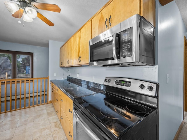 5252 5th St NE, Columbia Heights, MN 55421 - kitchen featuring appliances with stainless steel finishes, baseboard heating, ceiling fan, dark stone countertops, and light tile patterned floors