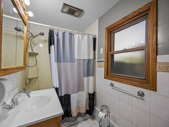 5252 5th St NE, Columbia Heights, MN 55421 - bathroom with tile walls, vanity, a textured ceiling, and tile patterned floors